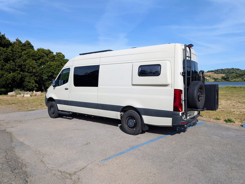 White camper van (RV rental) parked by a lake, with a ladder & spare tire on back. Perfect for travel adventures. — photo 10