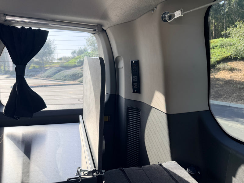 Inside a personalized rv rental: features a bed platform, essential power outlets, and a convenient privacy curtain. — photo 15