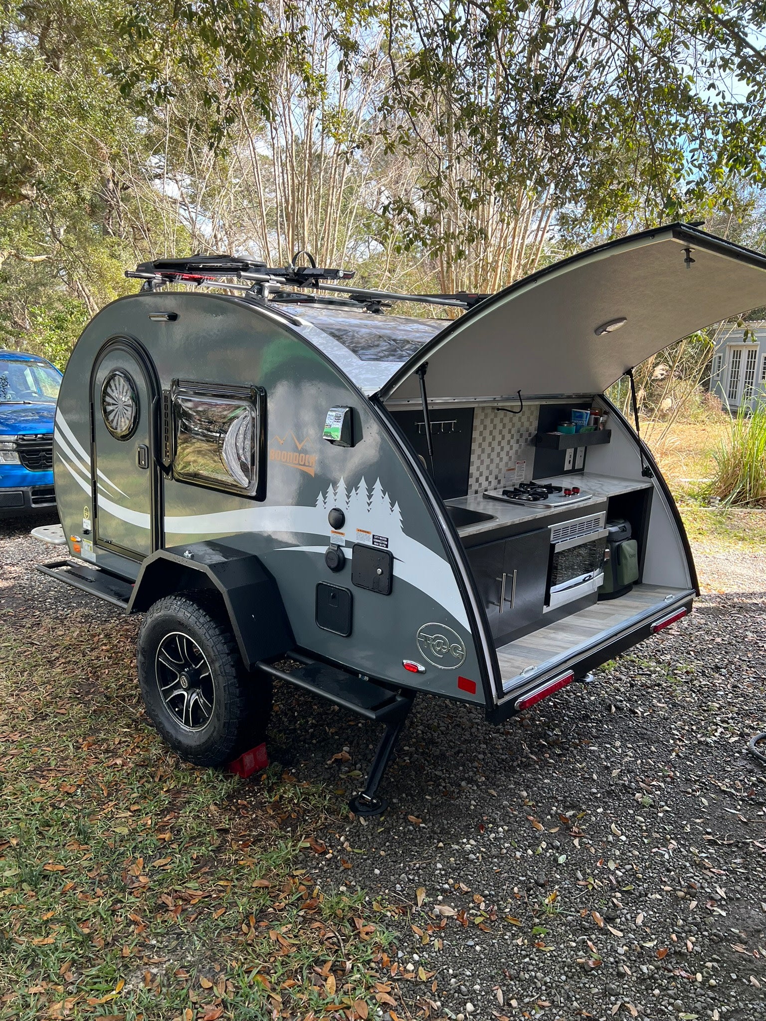 Grey Boondock teardrop camper RV rental with an open outdoor kitchen, ready for your next camping adventure.