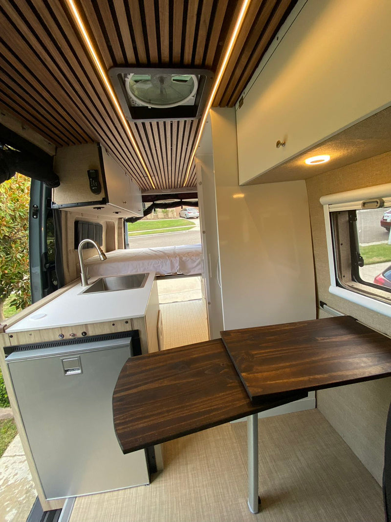  perfect for rv rental adventures. Features swiveling seats & wooden table for versatile living.|RV rental interior featuring a stylish kitchenette — photo 8