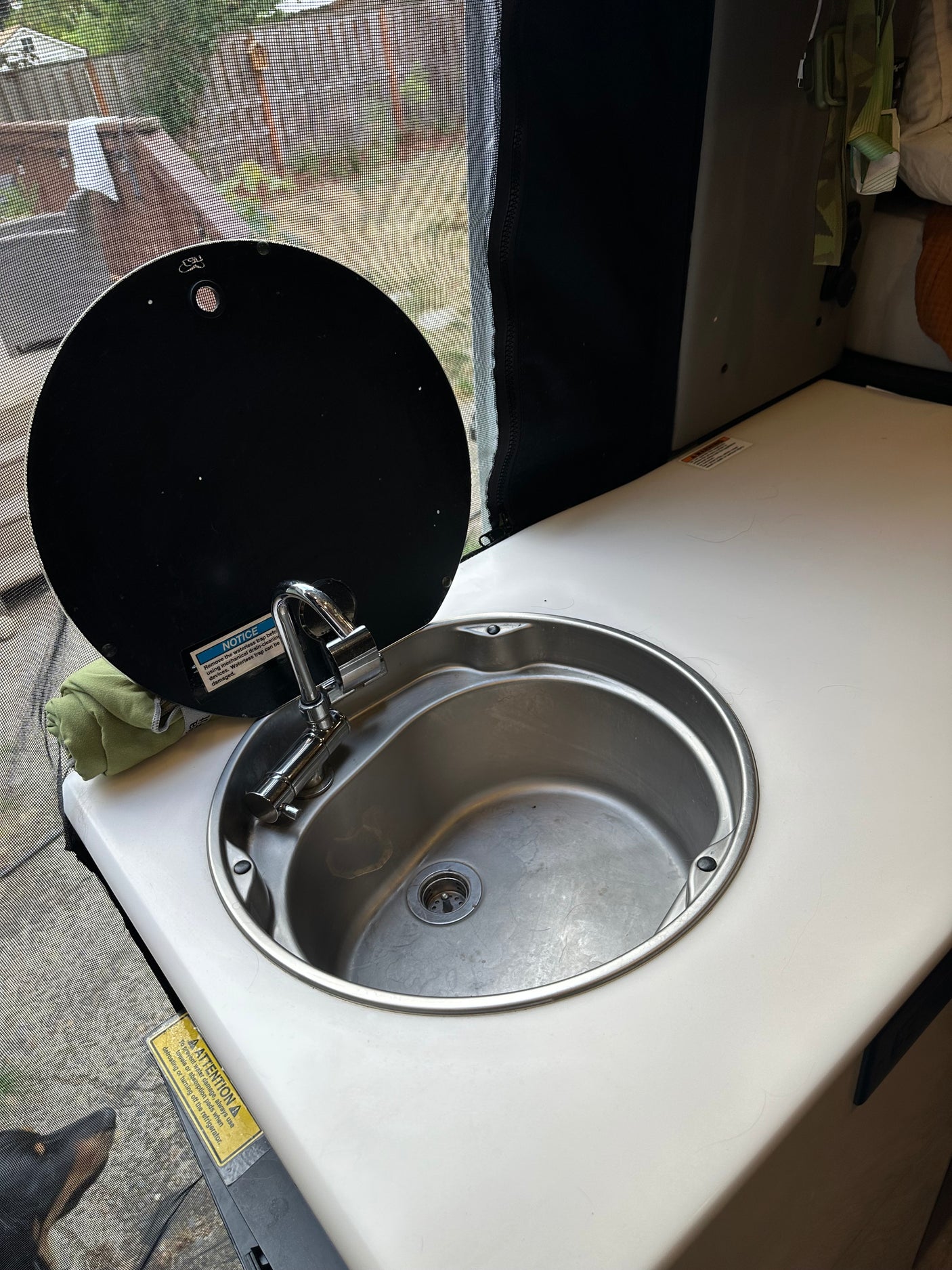 RV rental: Compact sink with faucet, lifted cover, & countertop. Practical for mobile kitchen needs in a camper.