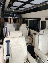 Experience comfort in this luxury RV rental van interior with quilted leather seats and modern lighting, perfect for travel.