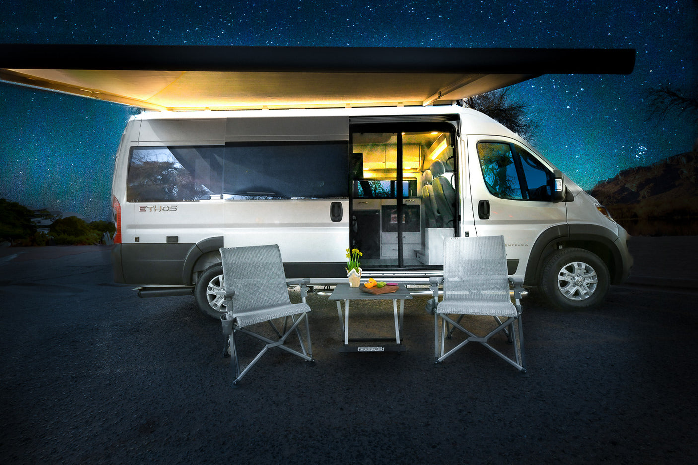 Ideal RV rental for starry nights! White camper van with illuminated awning, open door, chairs, and table set up.