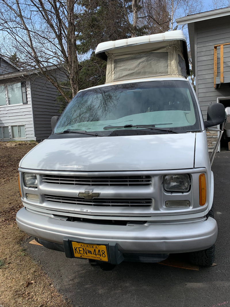 White pop-top camper van, a perfect Alaska RV rental. Front view shows details for your next adventure. — photo 12