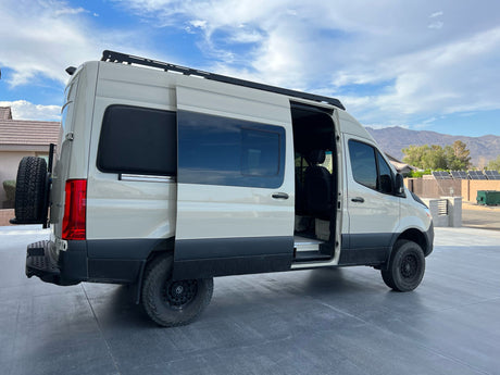 Spacious, off-road Sprinter camper van. Side door open, revealing interior. Perfect for an RV rental adventure.
