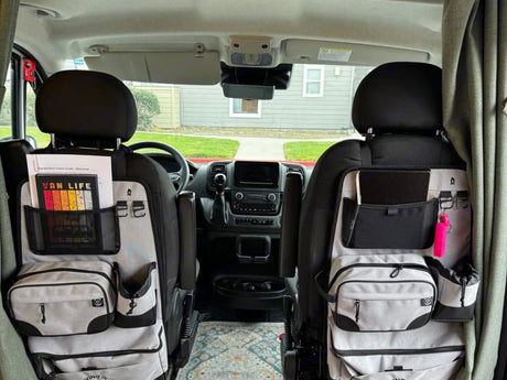 RV rental van interior: organized front seats with multi-pocket storage, ideal for van life and road trip essentials.