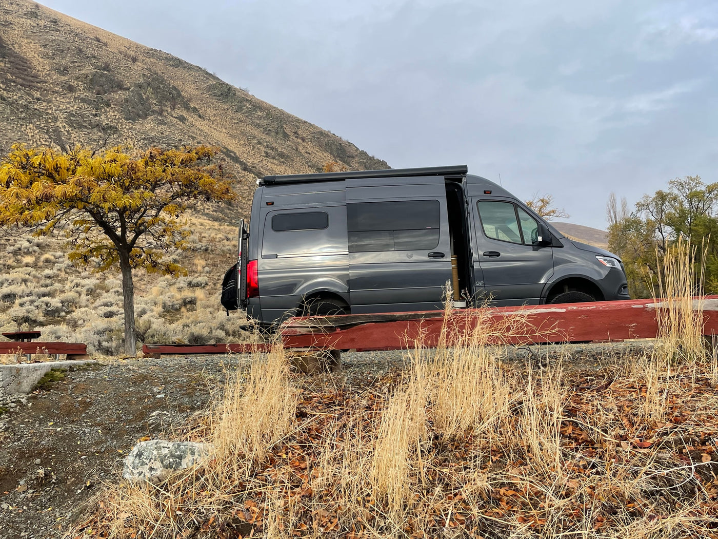  detailing a great experience with a comfortable camper van.|**RV rental** camper van set up at a desert campsite with a fire pit — photo 19