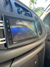Inside an rv rental: P.L.Z infotainment screen showing a backup camera view with parking lines. Dashboard and HVAC controls.