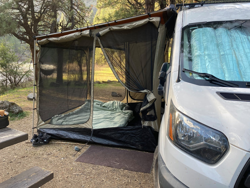 RV rental campervan with a spacious tent annex and bedding, set up at a riverfront campsite. Great for comfortable outdoor living. — photo 12