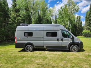  and two comfortable front seats.|This compact RV rental shows a modern camper van interior with swivel seats and a dining area — photo 9