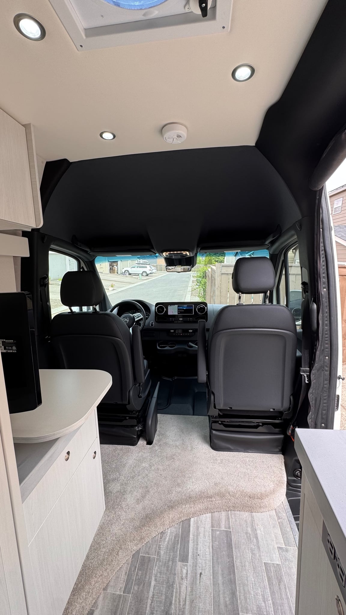  and rear sofa seating.|Explore this modern RV rental interior featuring a compact kitchen — photo 7