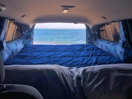 Cozy RV rental with a comfy bed and serene ocean view. Ideal for beach adventures and van life camping!