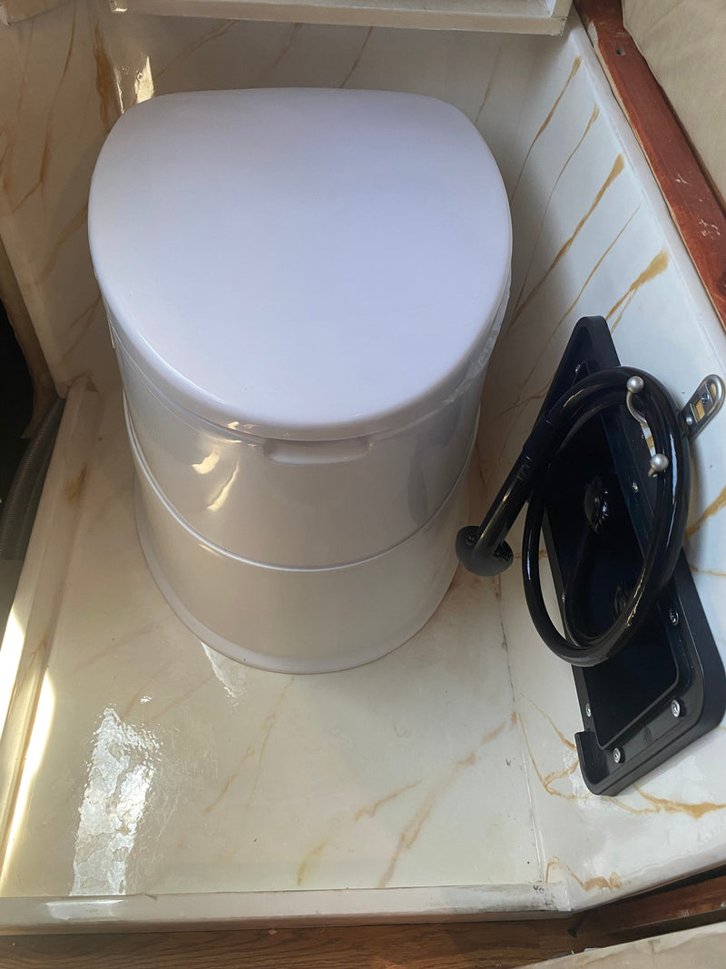 Compact portable toilet and shower hose in an RV rental bathroom. Offers convenient sanitation for your trips. — photo 13