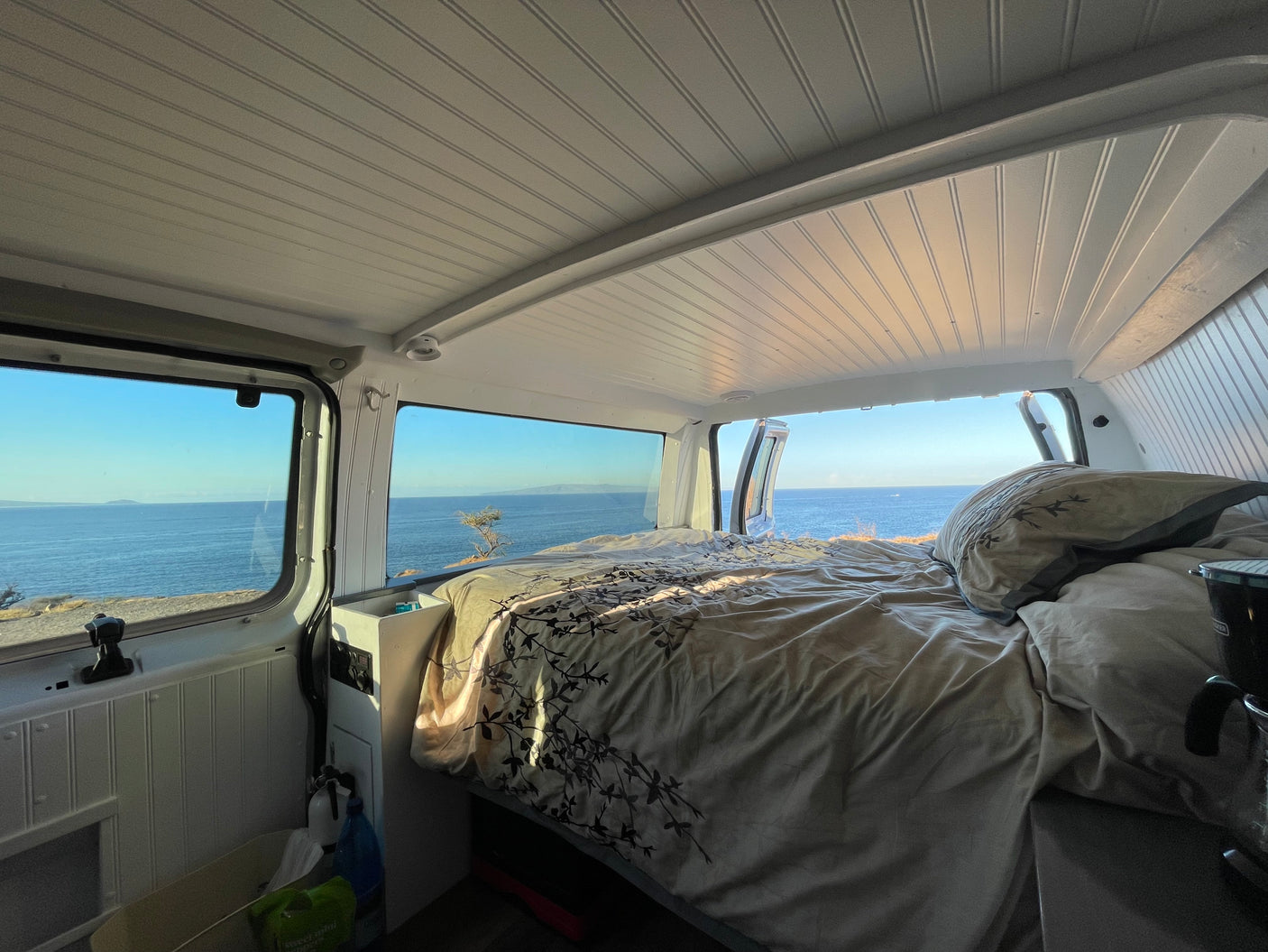 Comfortable RV rental interior with an amazing ocean view from the bed, perfect for scenic travels.