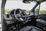 Inside a luxurious rv rental van: driver's area with modern steering wheel, dashboard screen, and quilted leather seats.