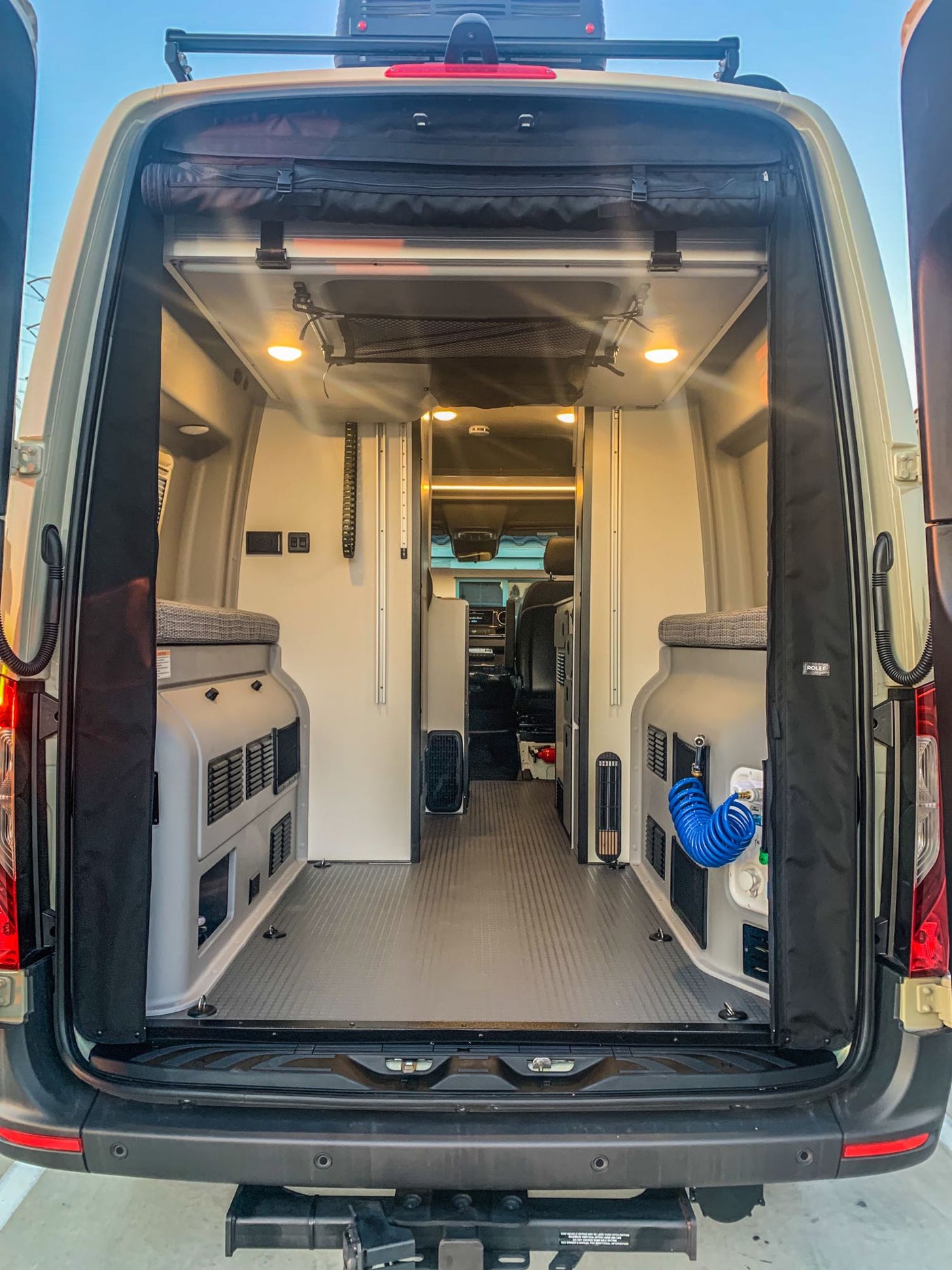  is parked on a dirt road under a full moon at dusk. Explore off-grid!|RV rental camper van: Rear view shows a well-equipped — photo 8