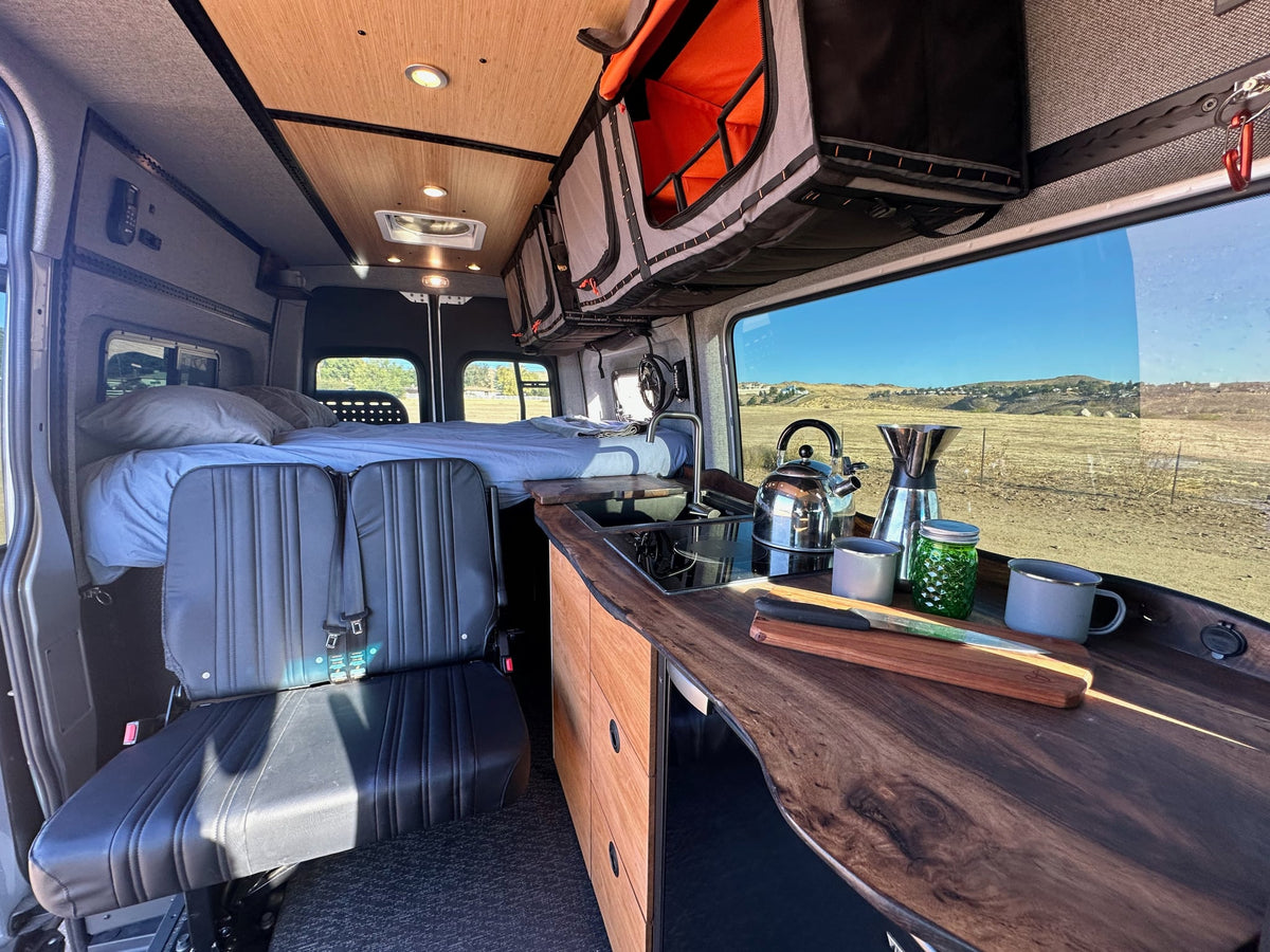  ideal for rv rental. Features mountain graphics & an open door revealing its custom interior.|RV rental interior: fully-equipped camper van with kitchen — photo 5