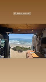 RV rental in Carlsbad, CA: Van's open doors frame a sunny beach and ocean view. Perfect for coastal adventures.