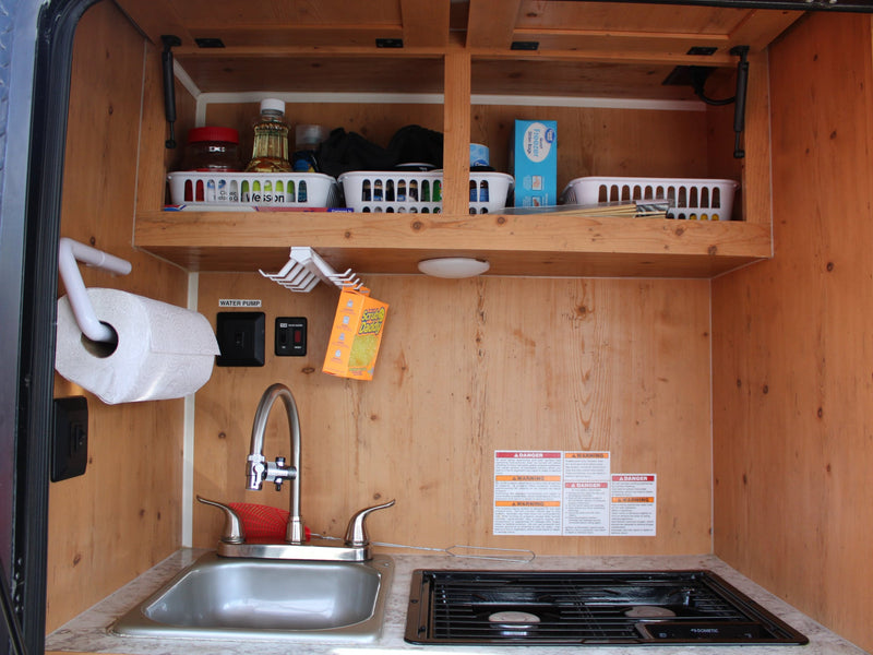  and an "EXIT" sign.|Inside an RV rental: a comfortable red and white dinette with wood walls and a plaid pillow — photo 7