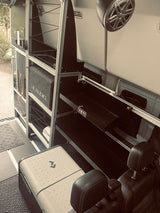 RV rental interior: custom storage with Yeti, JL Audio, & Dometic fridge for adventure. Power system visible.