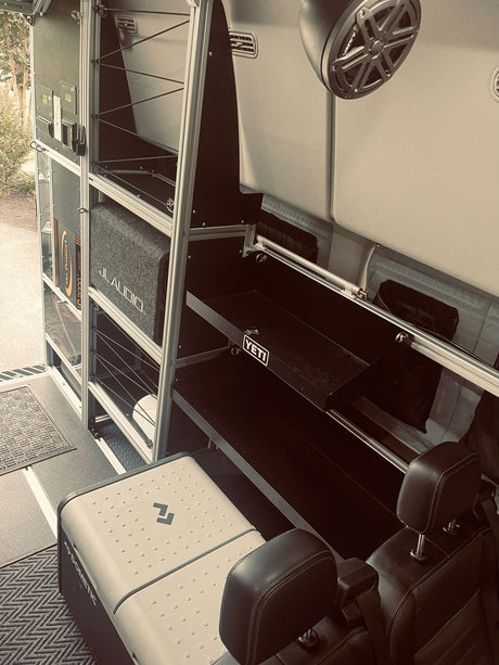 RV rental interior: custom storage with Yeti, JL Audio, & Dometic fridge for adventure. Power system visible.
