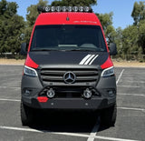 Front of a customized red & black Mercedes-Benz Sprinter van, great for rv rental. Features off-road bumper and roof LED lights.