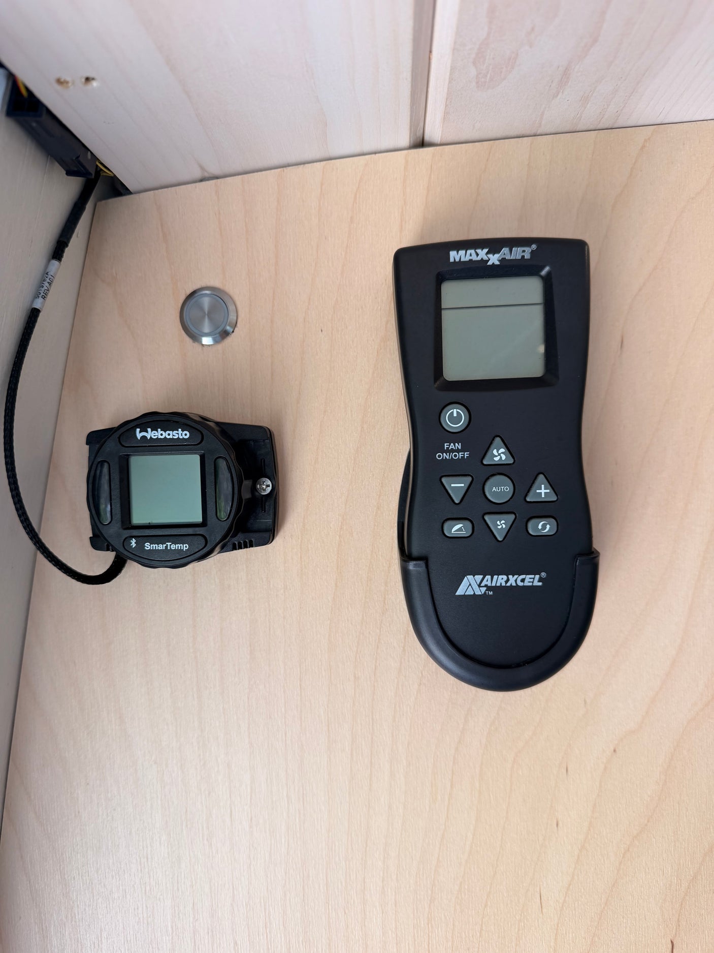 RV rental control panel: Webasto SmarTemp heater & Maxx Air fan remote on light wood.
