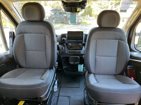 Inside this RV rental camper van: comfortable front seats, dashboard, and a clear view ahead for your next road trip.