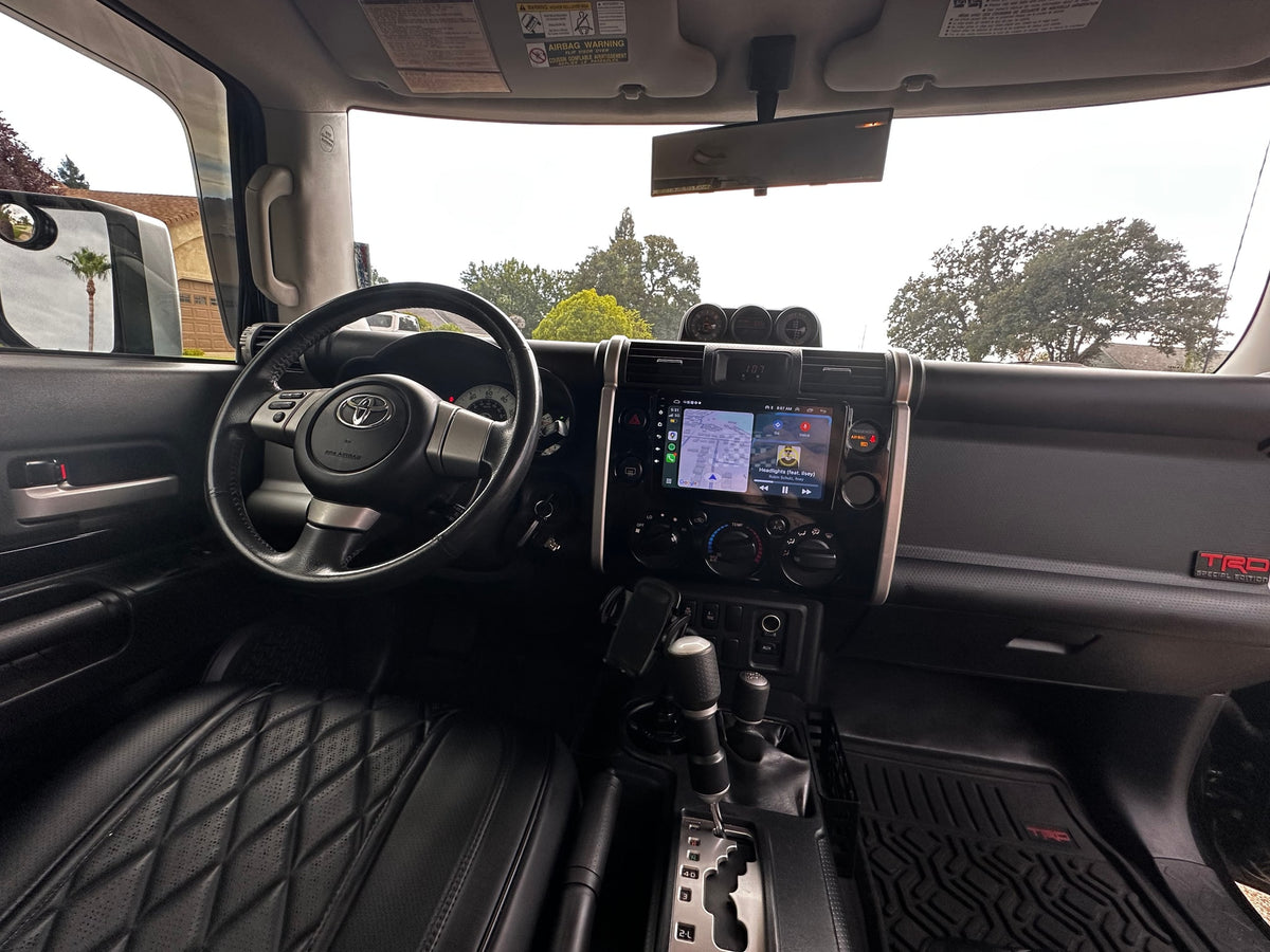 Inside an FJ Cruiser: driver's seat, dashboard with navigation, and view outside. Ready for your next **rv rental** adventure. — photo 8