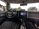 Inside an FJ Cruiser: driver's seat, dashboard with navigation, and view outside. Ready for your next **rv rental** adventure.