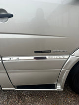 Close-up of a silver Roadtrek 3500 camper van's side, featuring 'Roadtrek' and '3500' badges. Great for an rv rental trip.