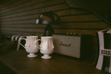 A cozy rv rental interior features unique face mugs, a Marshall speaker, and warm wood paneling, offering stylish comfort.