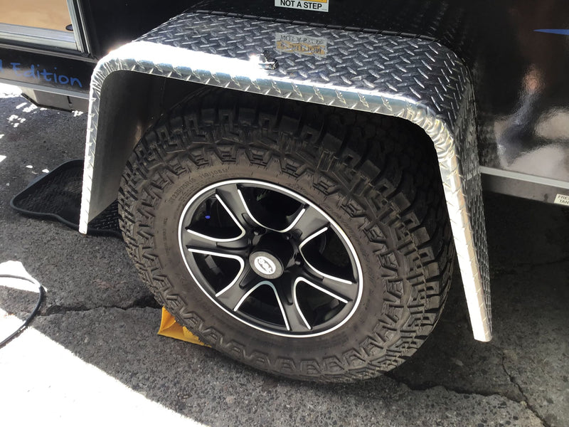 All-terrain tire and diamond plate fender of an RV rental, with a wheel chock. Parked & ready for adventure. — photo 11