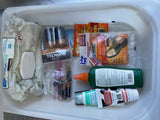 RV rental trip essentials: baby wipes, batteries, hand/toe warmers, insect repellent, and hand cream in a storage bin.