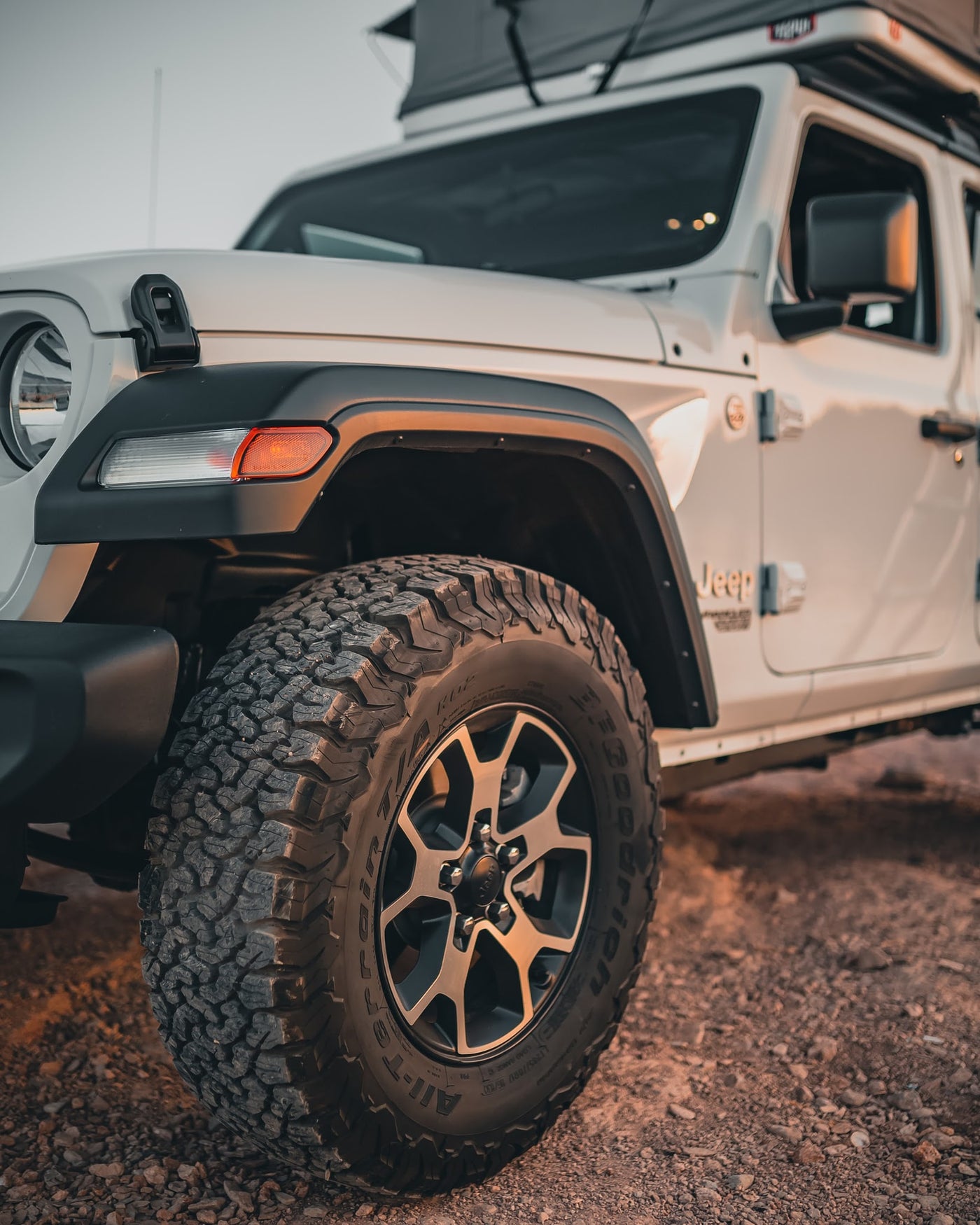 White Jeep with rugged tires and rooftop tent parked on a dirt path. Ideal for an outdoor adventure or a unique RV rental experience. — photo 12