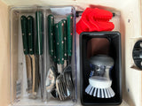RV rental kitchen: Organized green cutlery, a fun red T-Rex grabber, and an antimicrobial dish brush caddy for compact living.
