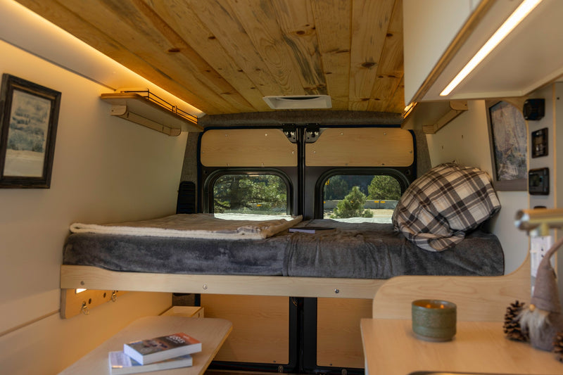 Cozy RV rental interior, featuring a plush bed, wooden ceiling, and a bright, functional design for comfortable mobile living. — photo 13