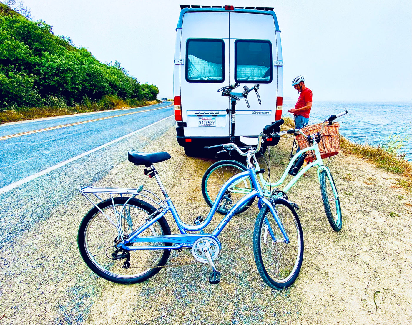  a person sips a drink on the camper van's roof amidst tall grass.||Cozy rv rental interior: dining table set — photo 22
