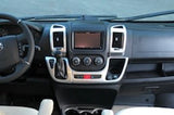 RV rental interior: driver's dashboard with steering wheel, central screen, climate controls, and gear shifter.