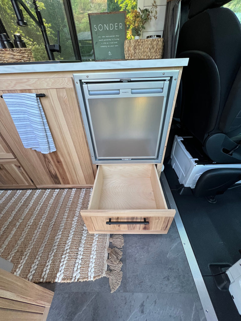  and an elevated bed/dog crate.|RV rental interior showcasing smart storage: open light wood cabinets — photo 11