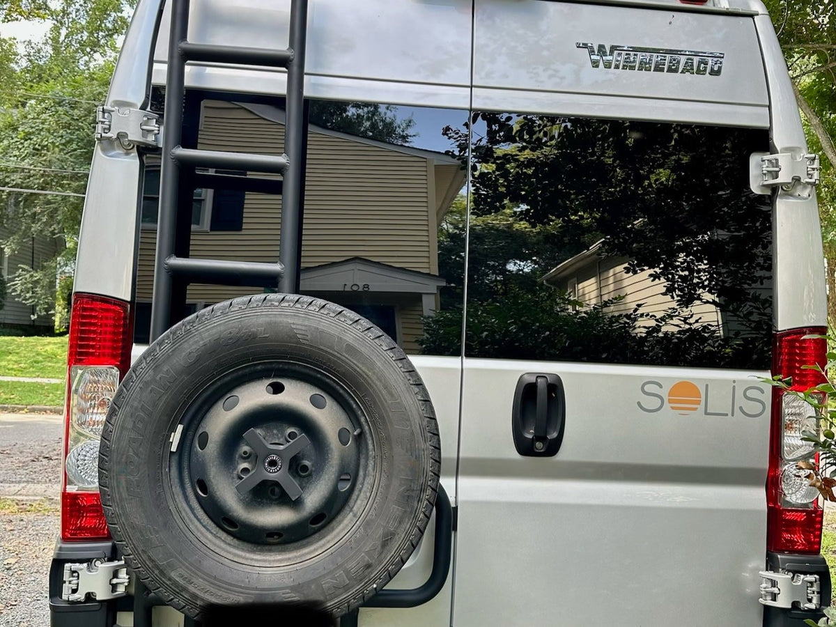  parked outdoors with a sunshade & leveling blocks.|This rv rental camper van — photo 5