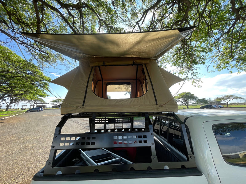 This truck with a tan rooftop tent offers portable lodging, perfect for your next outdoor rv rental adventure. — photo 4