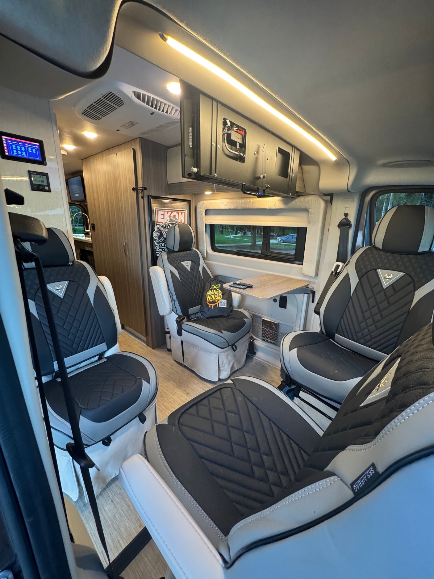 Experience a comfortable rv rental interior: plush seating, a dining table, modern controls, and ambient lighting for luxury mobile living.