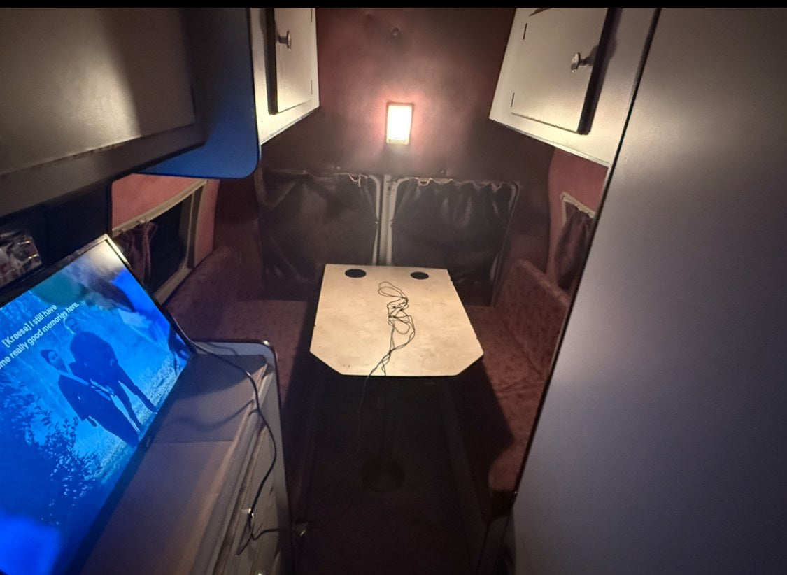  soft ambient lighting. Perfect for comfortable road trip adventures.|Cozy RV rental interior: a compact living space with a dining booth — photo 6