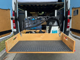 RV rental: Pull-out storage drawer, netted bins, and propane tank optimize space in this van conversion.