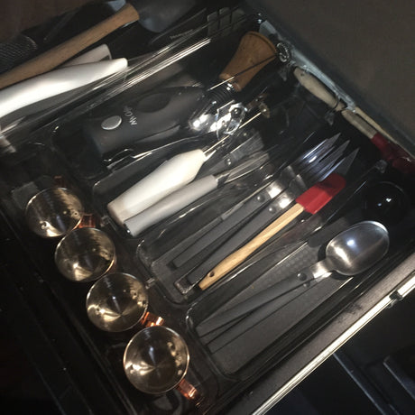 RV rental kitchen drawer: neatly organized with flatware, cooking utensils, measuring cups, and a Mr. Coffee frother.