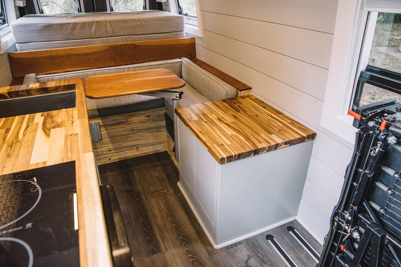  and window offer comfort in this camper van.|RV rental interior: A cozy dining area with two rear passenger seats — photo 13