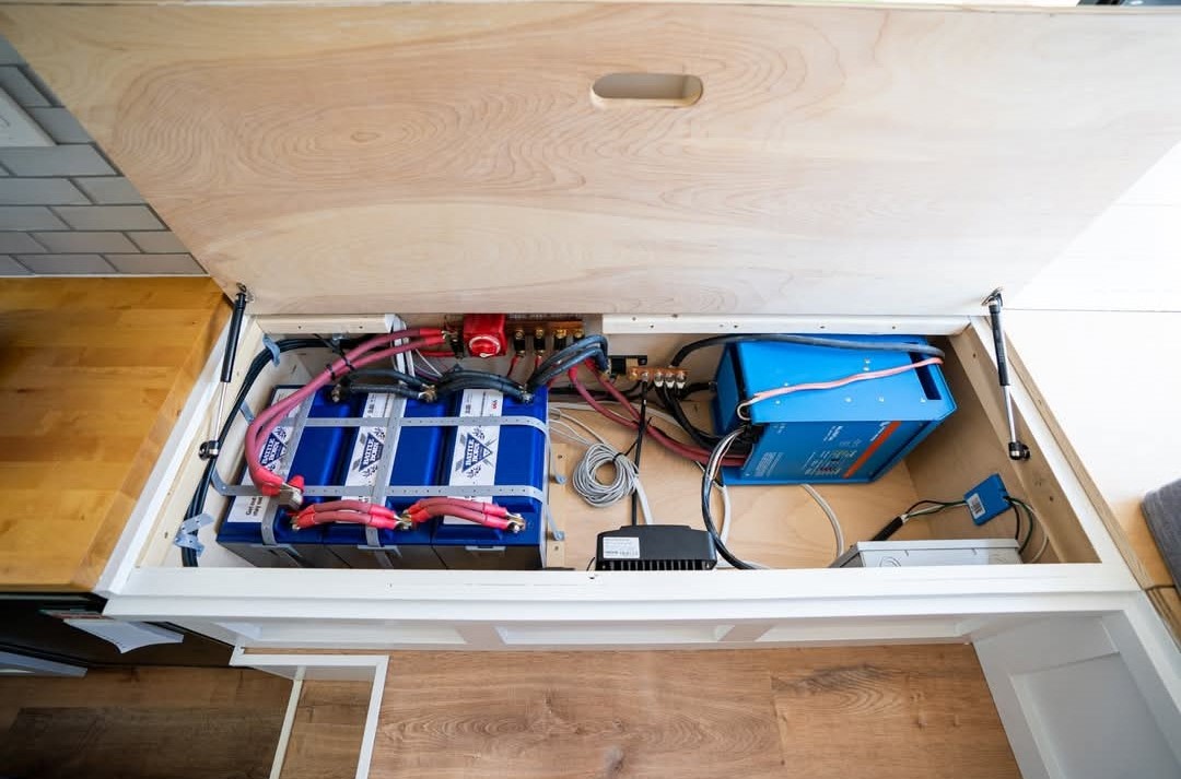 RV rental's power hub: Blue Battle Born lithium batteries, Victron inverter, and wiring for reliable off-grid use.