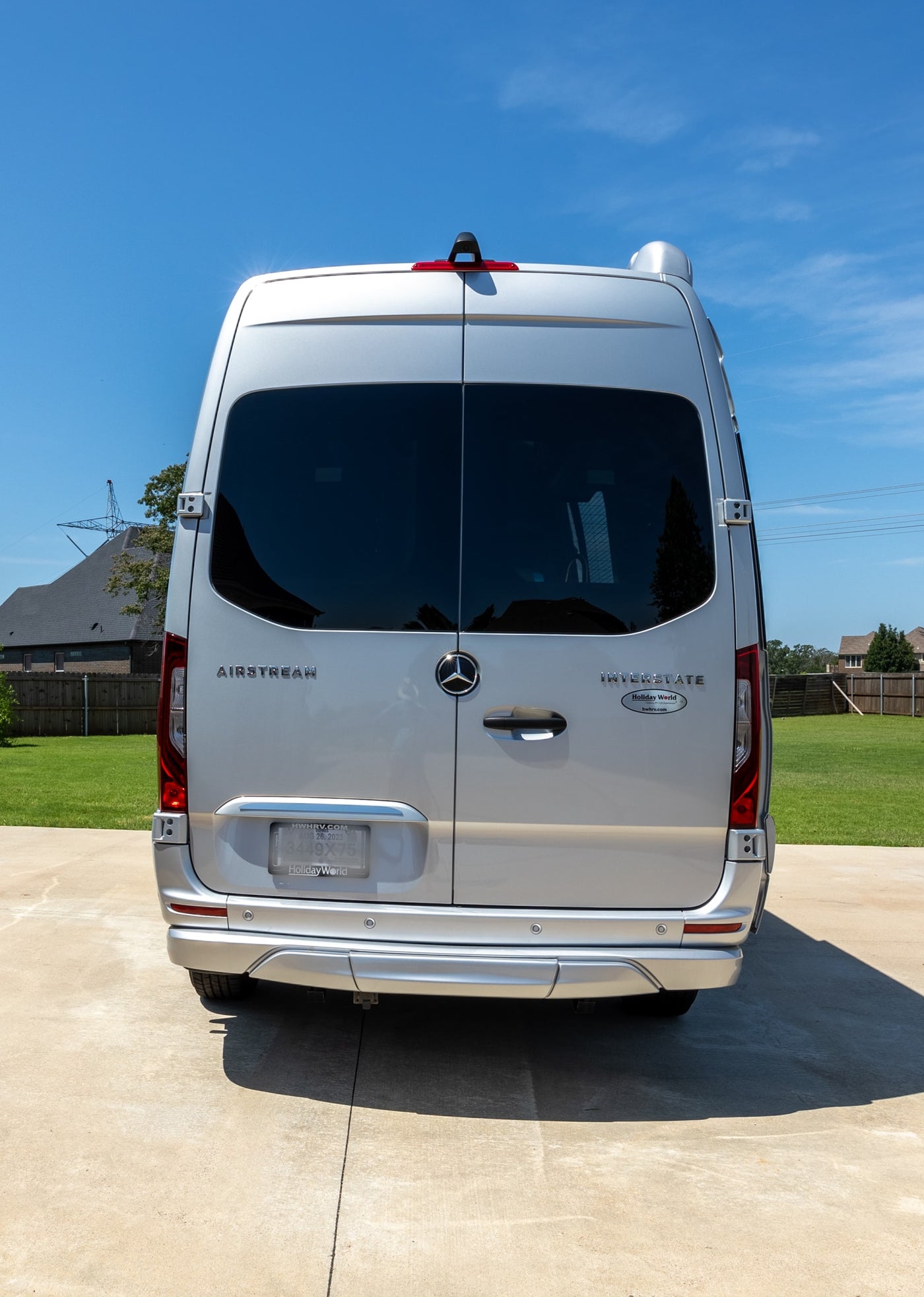  sunny view of a silver Airstream camper van parked on a driveway — photo 11