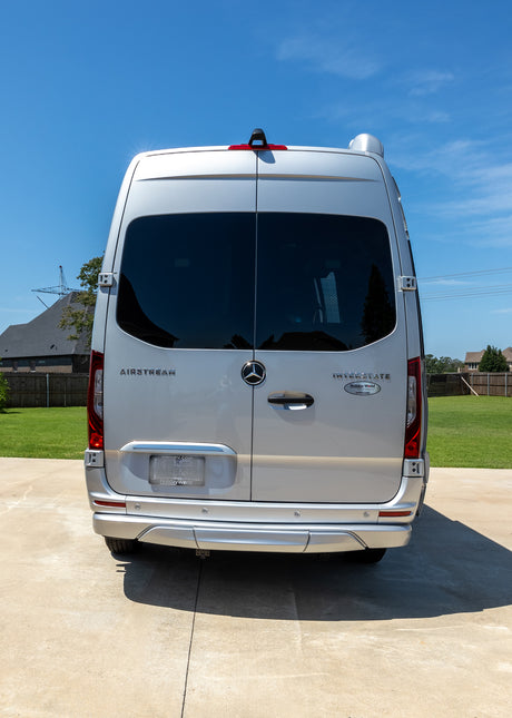 Rear view of a silver Mercedes-Benz Airstream Interstate RV, ideal for an RV rental adventure.